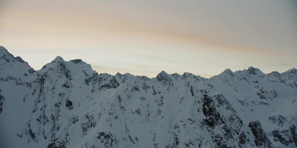 Snow covered mountains under a cloudy blue sky