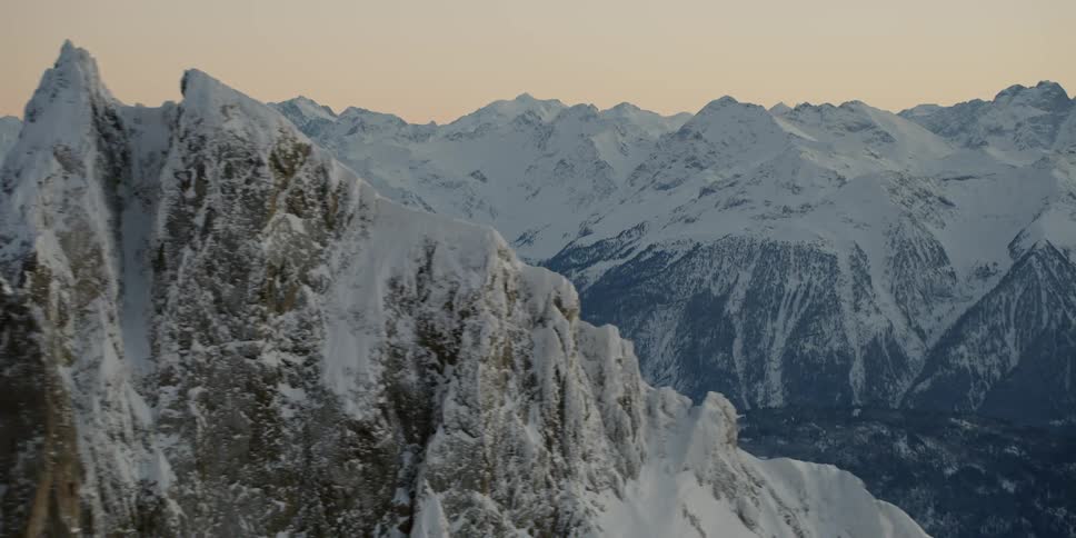 The sun sets over snowy mountains