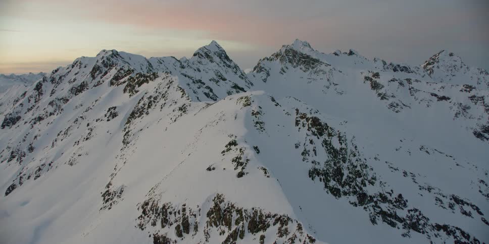 Snow covered mountain peaks at sunset