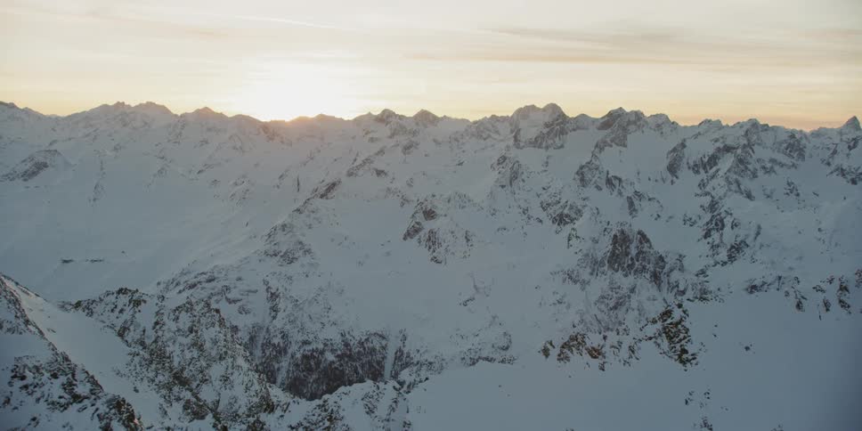 Snow covered mountain ridges at sunset