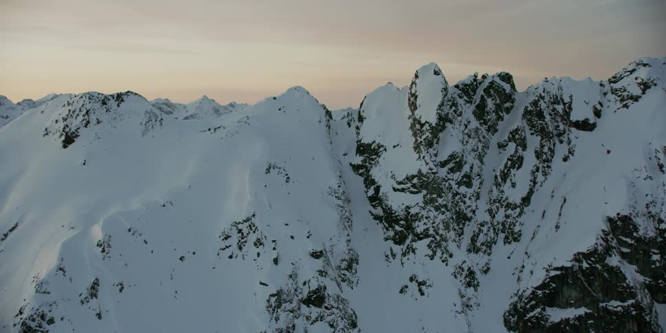 The sun sets over snowy mountains