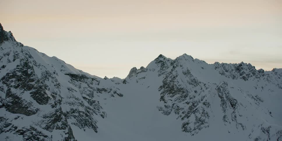 Snow covered mountain ridges at sunset