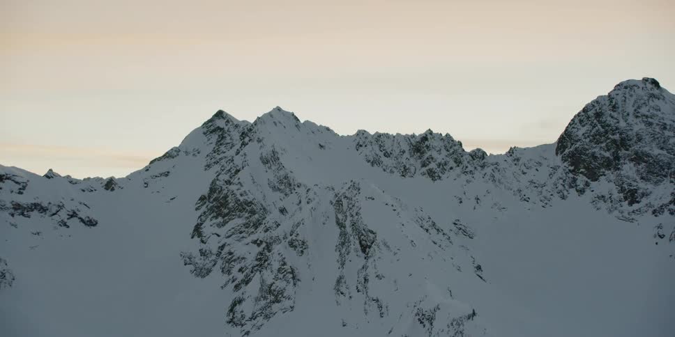 Snow covered mountain ridges at sunset