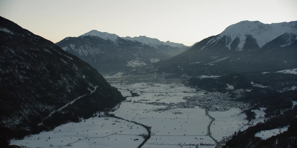 Snow covers a mountain landscape at sunrise