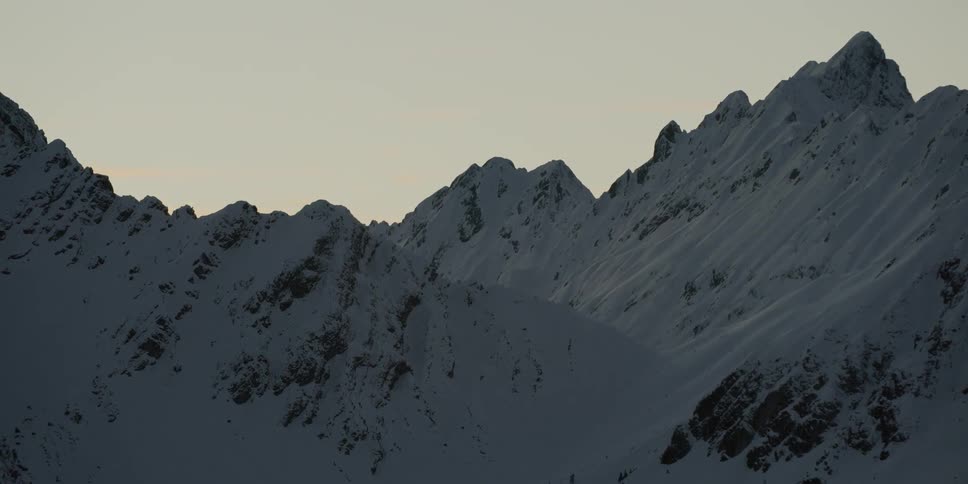 Snow covered mountain ridges at sunset