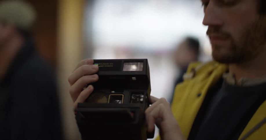 A man takes a polaroid picture