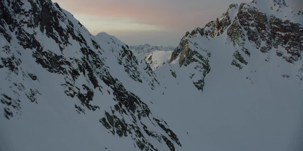 The sun sets over snowy mountains
