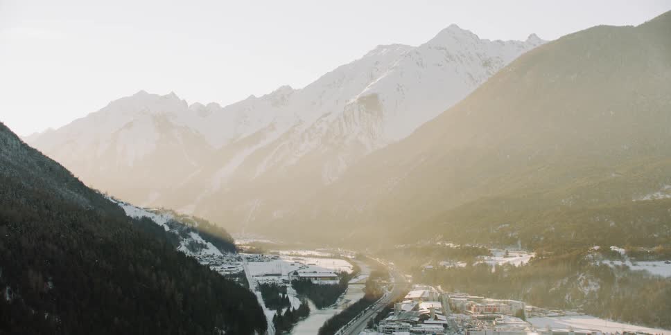 The sun sets over snowy mountains