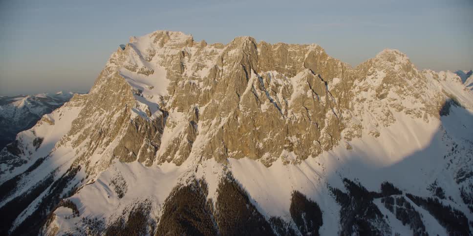 Snow covers a rocky mountain ridge
