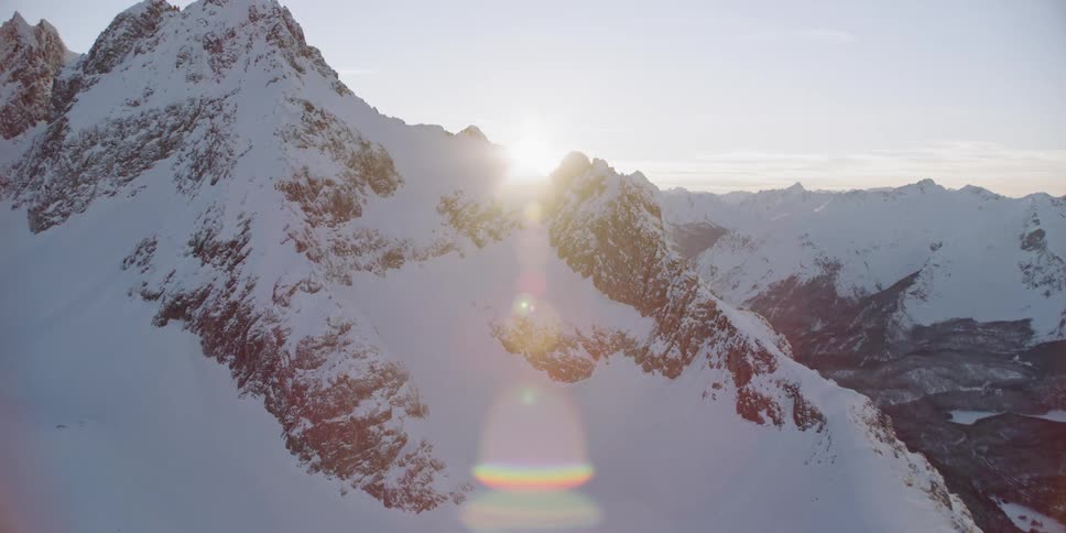Snow covers mountains at sunset