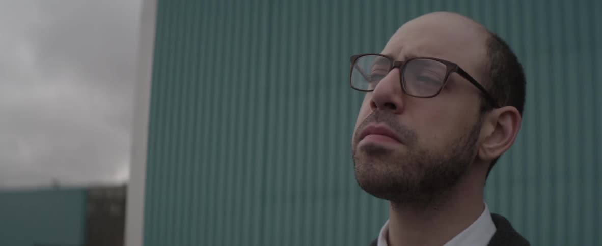 A man wearing glasses looking up and around him