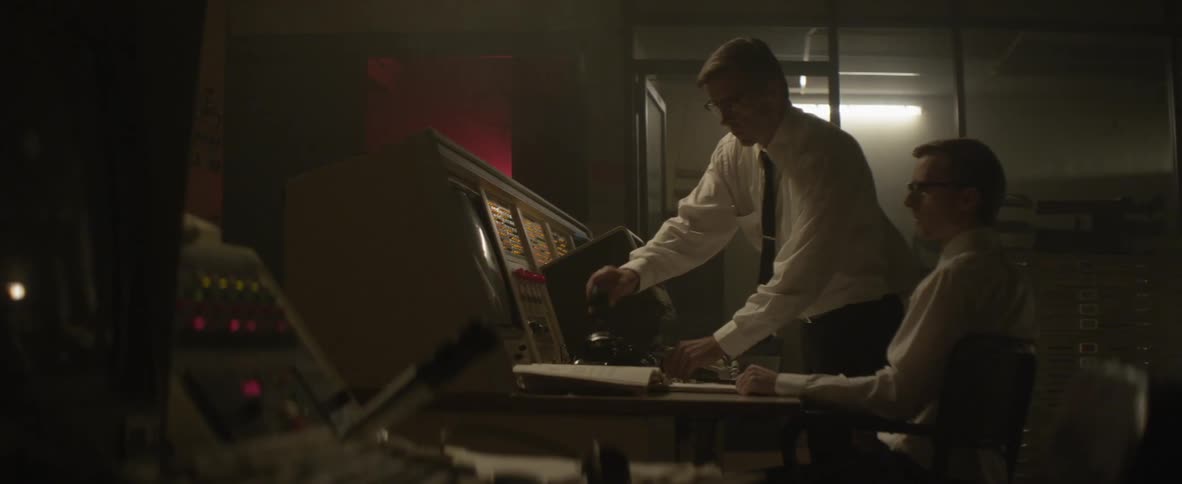 Two people stop to examine a control panel
