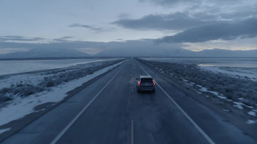 An suv travels on a coastal road on a winter day