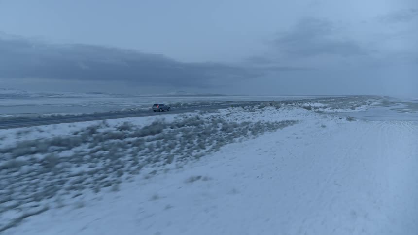 A car travels through a snowy landscape