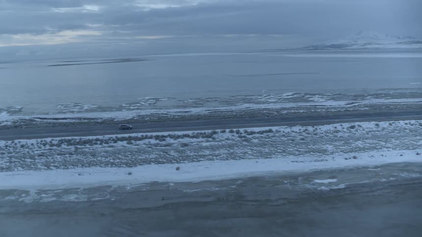 A car travels on a lakeside road