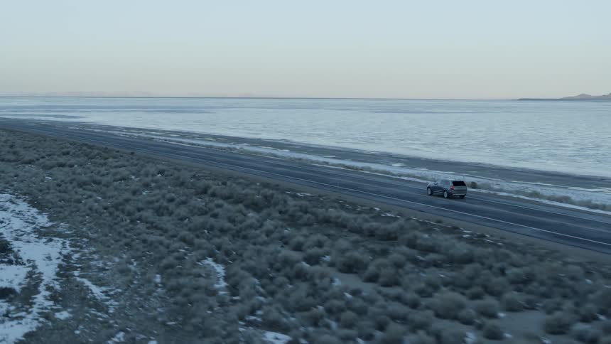 Vehicle travels on a rural road at sunrise