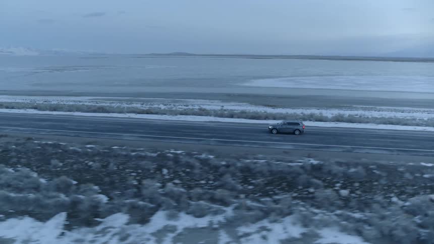 Car drives on a rural road at dusk