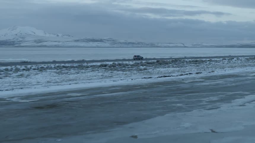 A truck drives on a coastal road