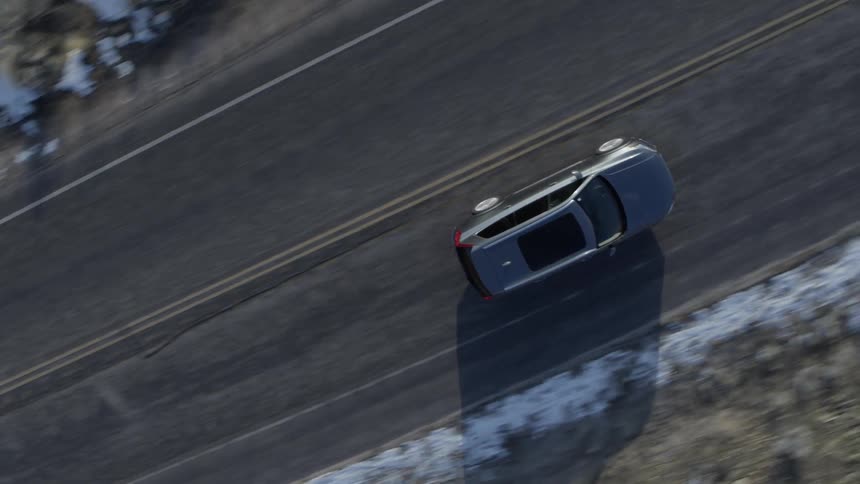A car travels on a snow lined road