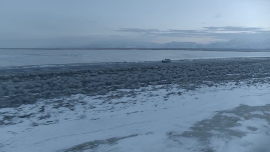 A car drives down the coastal road