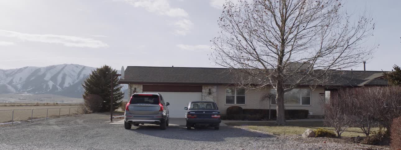 Vehicle pulls into a driveway in front of a house