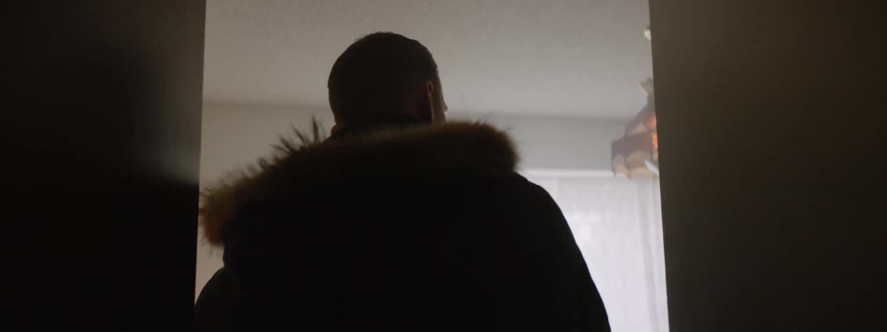A man is entering a room in a house in daylight