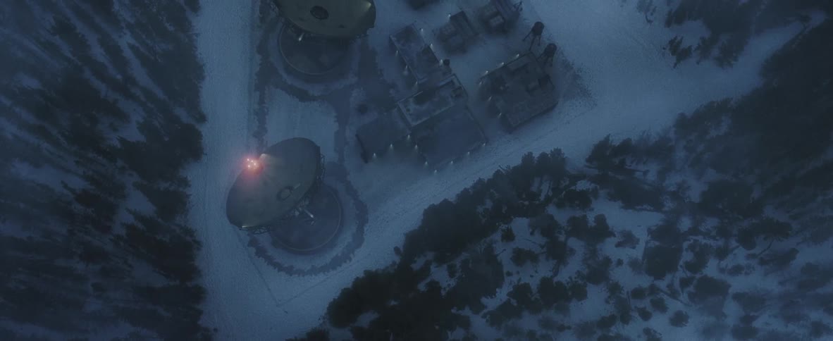 A forest clearing with a military compound and large satellite dishes
