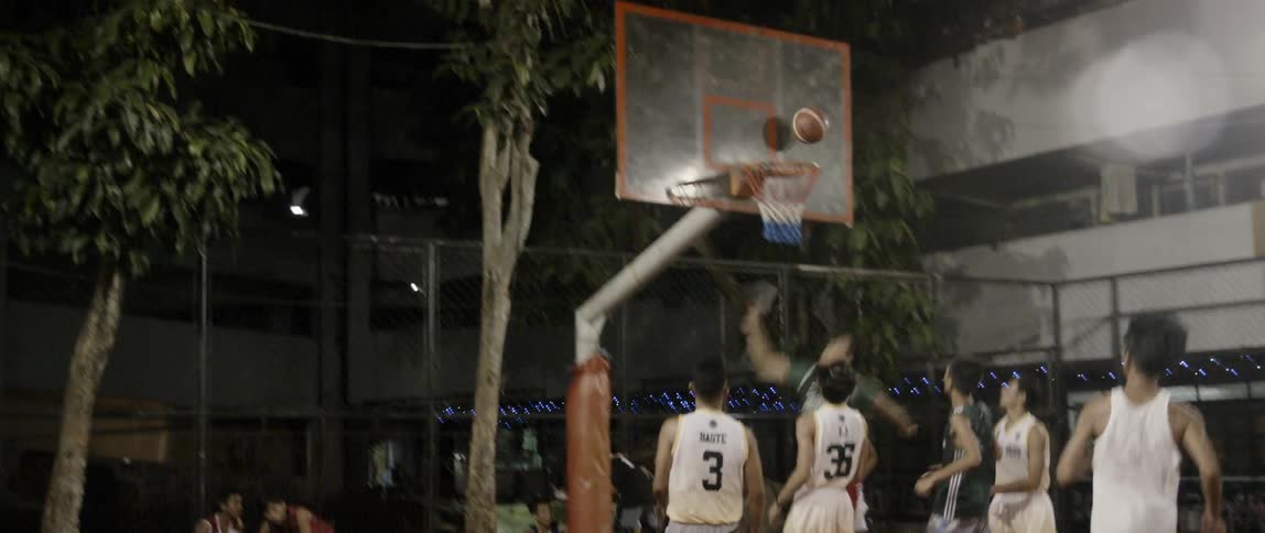 Men play basketball on an outdoor court