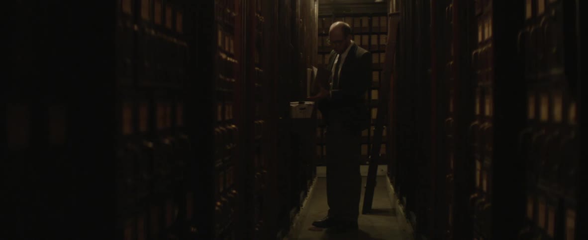A man looking through a book in the library