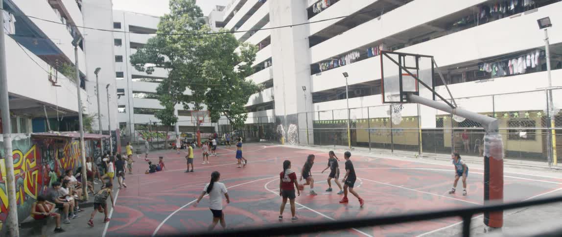 Teenagers play on an outdoor basketball court