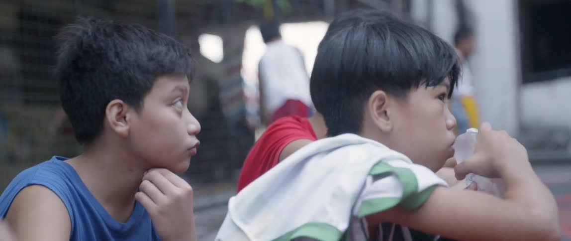 A group of children sit outside