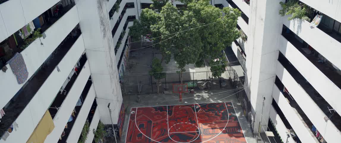 A basketball court and trees in a courtyard on a sunny day