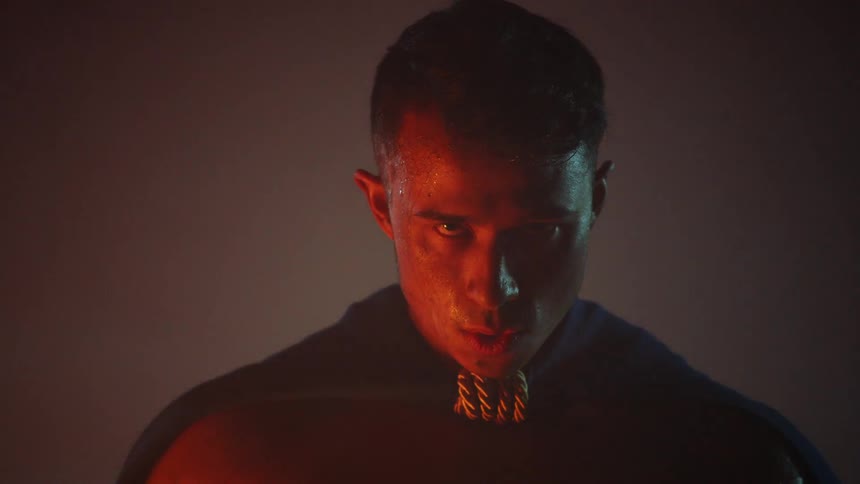 A man is standing outside at night sweating