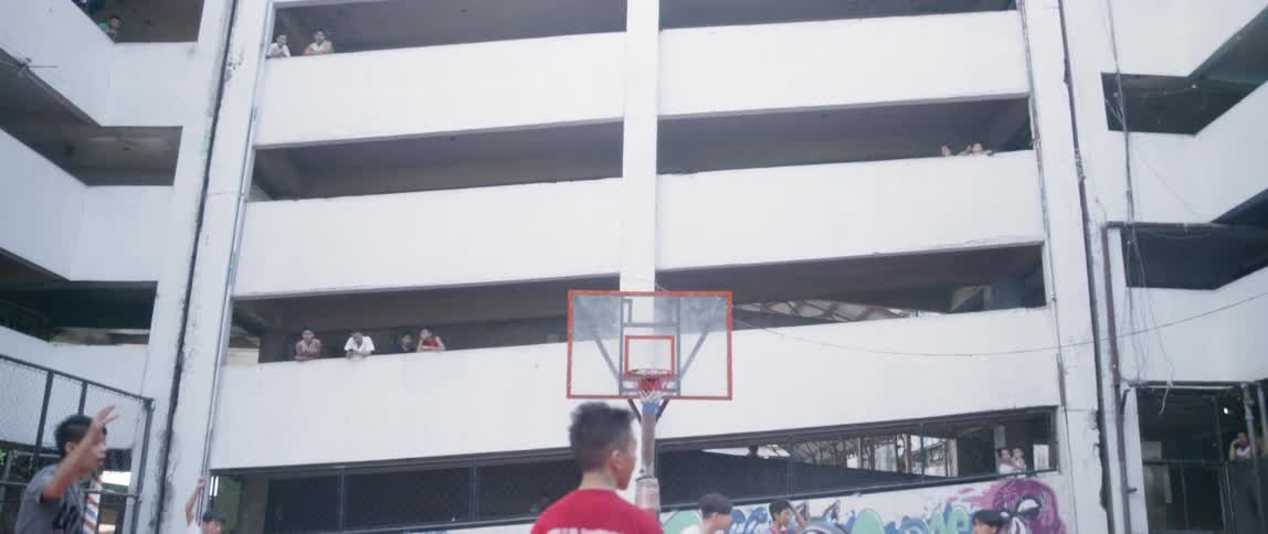 Boys play on an outdoor basketball court