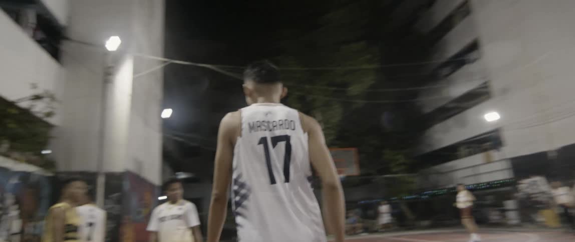 Men play basketball on an outdoor court