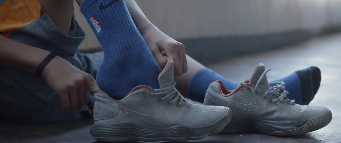 Young person slips shoes on over socks