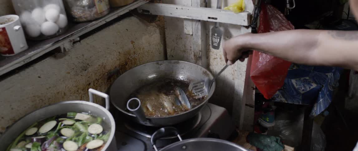 Man transfers two fish from one pot to another