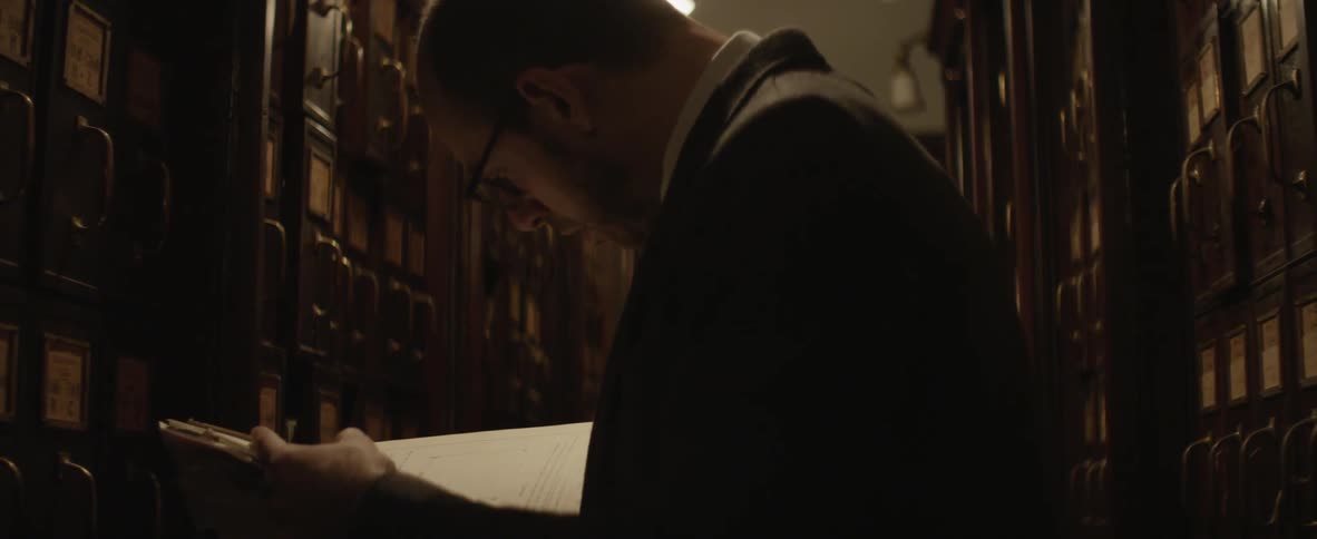 Man looking through papers in a library