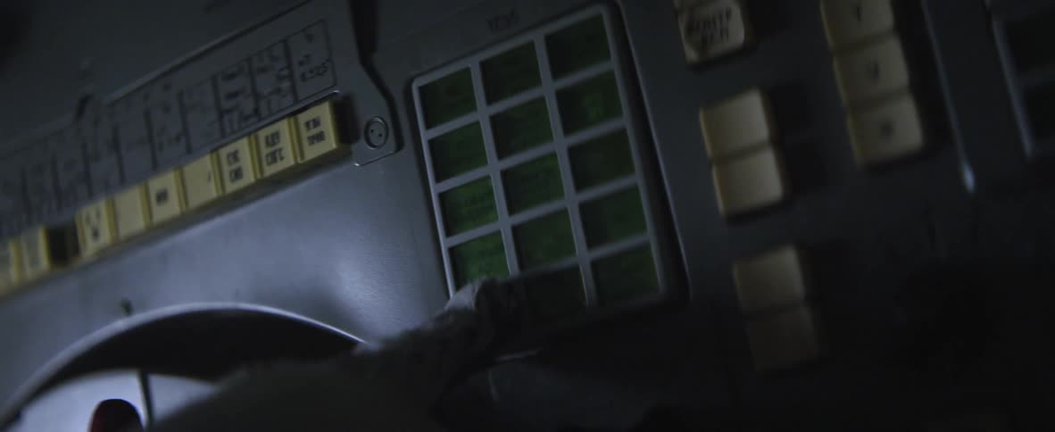 A gloved hand keys information into a machine
