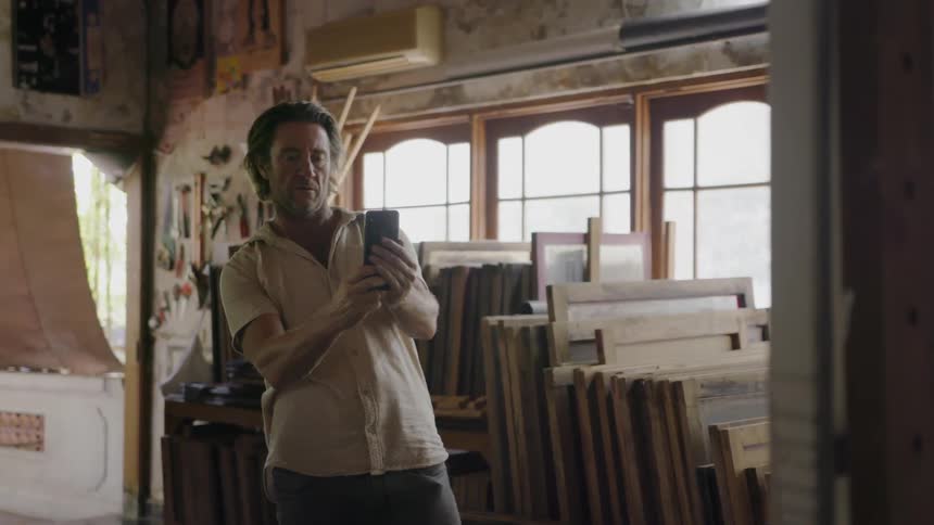 A man steps back and takes a photo with his phone