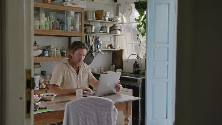 A man uses a laptop at a desk