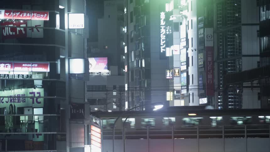 A commuter train travels in a city at night