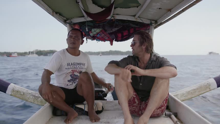 Two men talk while riding in a boat