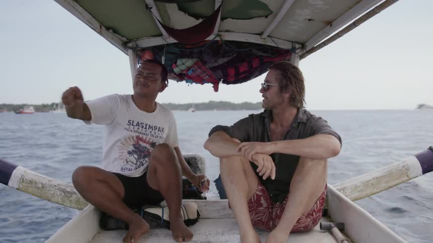 Two men talk while riding in a boat