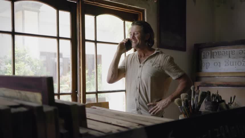A man uses a phone inside the house