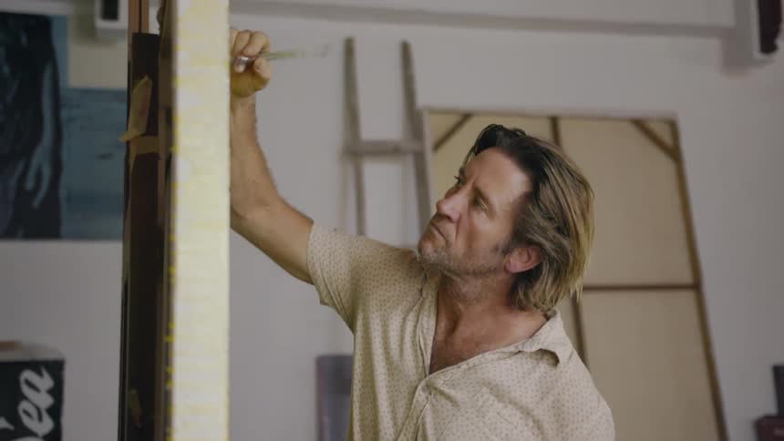 Man paints on an art canvas