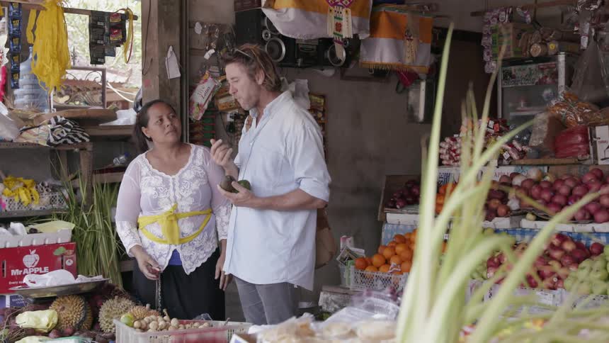 A man eats fruit in a market