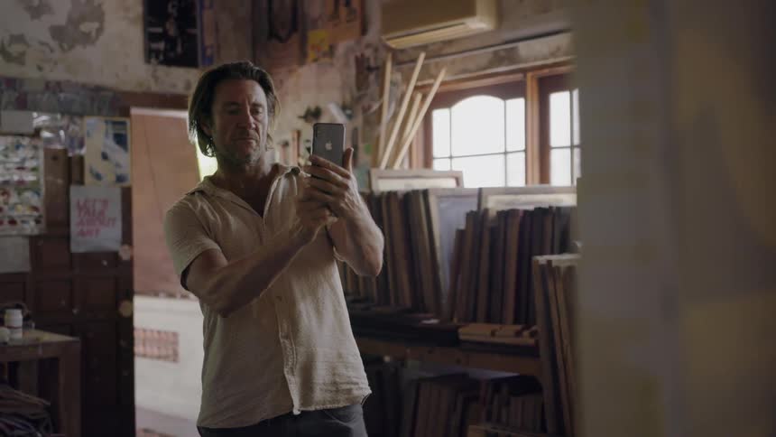 Man takes a photograph of a painting