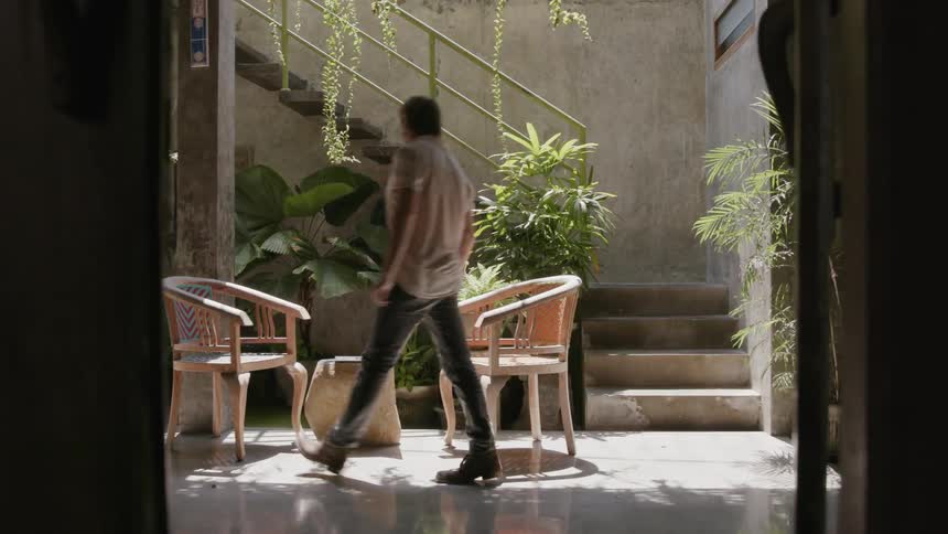 Man walks down steps and sits in a chair