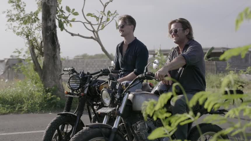 Two men talk on motorcycles